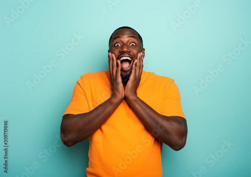 Cuadros en Lienzo Amazed and shocked expression of a boy over cyan background