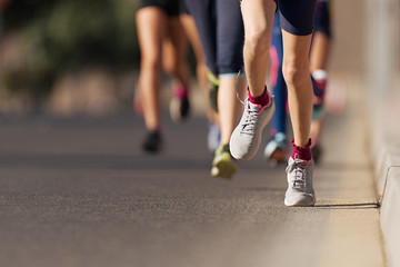 Wall Mural - Running children, young athletes run in a kids run race,running on city road detail on legs