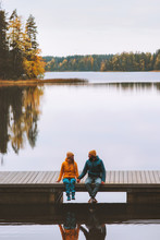 Couple Friends Traveling In Finland Family Lifestyle Love Relationship Man And Woman Sitting Talking On Pier Outdoor Lake And Autumn Season Forest Landscape