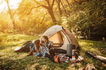 young loving couple in camping in the forest. beautiful woman and handsome man spending time togethe