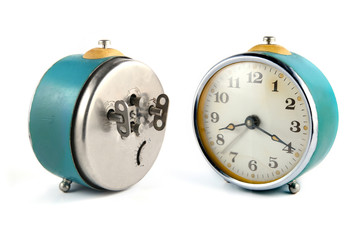 Back side and front side of old mechanical table clock isolated on white background.