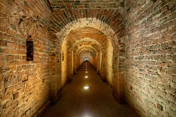 Brick archway made of red bricks as a passage between the two wings of a medieval castle. Granite stone an brick built Interior passage to bastions