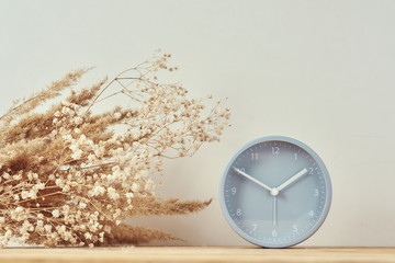 Wall Mural - Alarm clock and homemade vase with dries plant on a wooden table