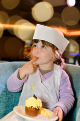 Canvas Print - young apprentice pastry chef tasting her cake