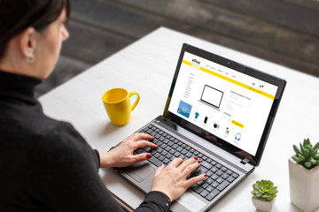 Wall Mural - Woman shopping online with laptop computer from home. Modern flat design e-commerce web site with technology products