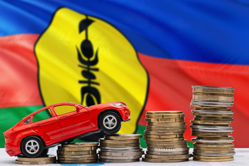 New Caledonia savings concept. Money for new automobile, toy car and coin piles standing on national flag background. Copy space for text.