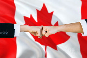 Wall Mural - Canada agreement concept. Man and woman fist bumping on national flag to show cooperation. Peace and teamwork theme.