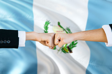 Wall Mural - Guatemala agreement concept. Man and woman fist bumping on national flag to show cooperation. Peace and teamwork theme.