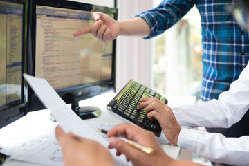 hand team of programmers are discussing the use of online business investment management software in
