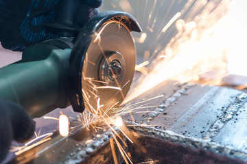 Cut metal with a Angular grinding machine. Sparks are flying. Construction tool grinder. A man is cutting metal. Wear gloves for safety.