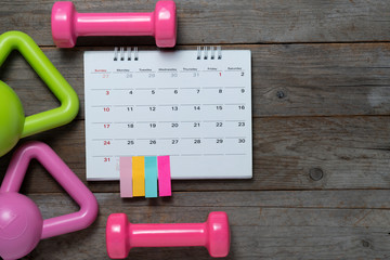 Wall Mural - Time for exercising with calendar and sport equipment on the wooden table background