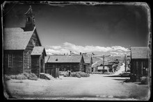 Vintage Black And White Old Looking Photo Of Empty Streets Of Abandoned Ghost Town Bodie In California, USA In The Middle Of A Day.