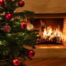 Christmas Tree Close Up On Burning Fireplace Background