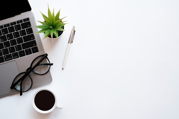 Wall Mural - Work space office business and accounting concept on white table desk with laptop computer and coffee cup, green plant and glasses, Top view with copy space, flat lay