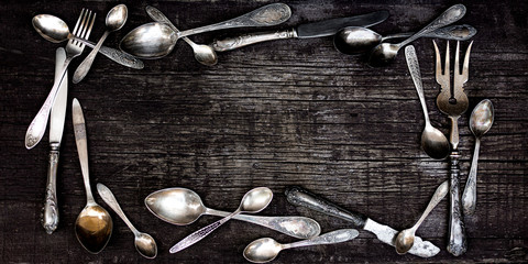 Wall Mural - Vintage cutlery - spoons, forks and knives on an old wooden background.