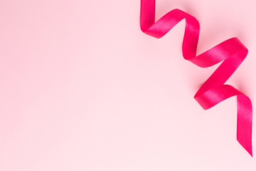 Wall Mural - Gift ribbon fuchsia color on pink background. Minimalistic composition for the holidays.