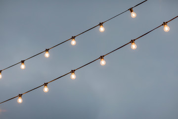 lamp light bulbs on sky background. christmas street mood