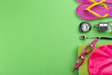 Flat Lay Composition With Swimming Accessories On Green Background. Space For Text