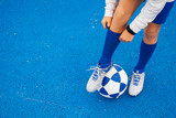 Fototapeta Sport - Little unrecognizable boy playing soccer of blue background
