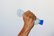 © Adrian - Hand squeezing Plastic Bottle representing movement against pollution and for recycling.