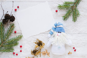 Wall Mural - Snowman, branches of fir tree, notebook, red berries on wooden background