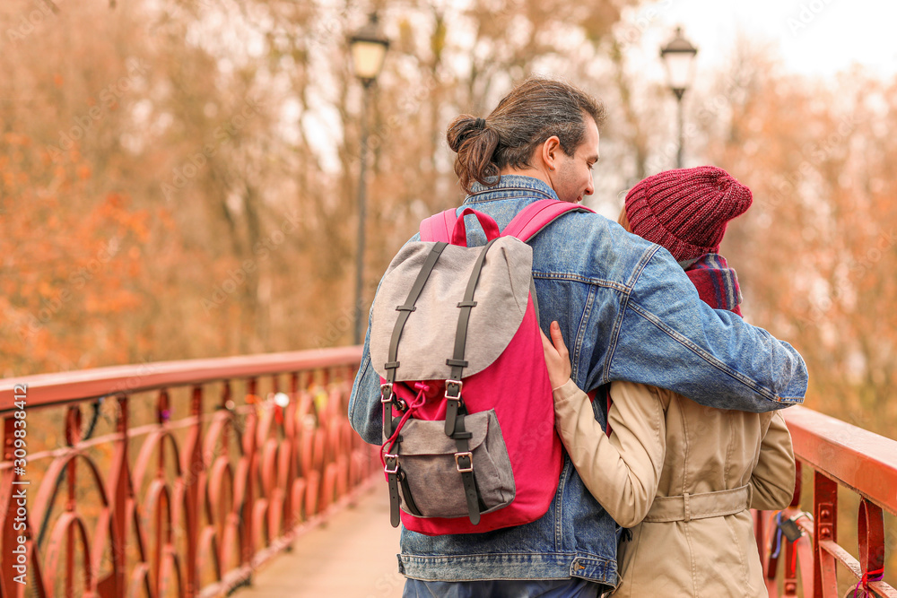 Happy couple on bridge in autumn city