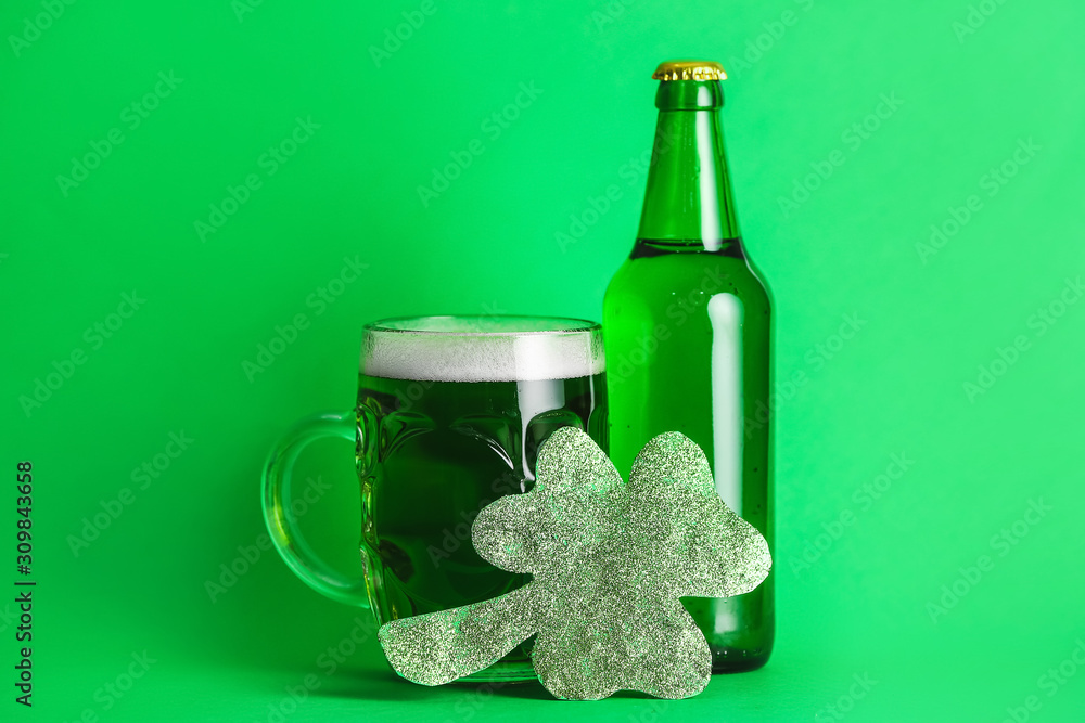 Green beer and clover on color background. St. Patrick's Day celebration