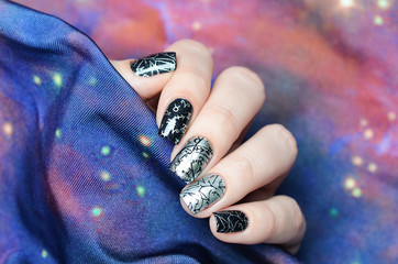 black and gray manicure with a constellation map pattern on a cosmic background