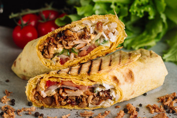 Shawarma sandwich gyro fresh roll of lavash pita bread chicken beef shawarma falafel RecipeTin Eatsfilled with grilled meat, mushrooms, cheese. Traditional Middle Eastern snack. On wooden background