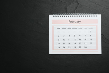 Wall Mural - February calendar on black stone background, top view. Space for text