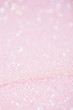 Vertical pink background with closeup light sparkling glitter texture