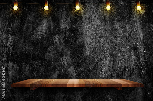 Photographie Empty brown plank wood shelf at black grung concerte wall background with light