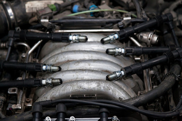 Wall Mural - Spark plugs with high voltage wires on the engine under the hood of a car during diagnosis and repair in a workshop for vehicles. Auto service industrial.