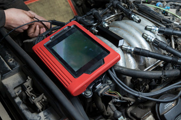 Wall Mural - Checking the condition of the surface of the engine cylinders using an endoscope camera with a wireless display showing scratches on the unit for overhaul and diagnostics. Auto service industrial.