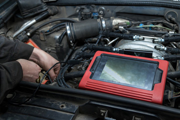 Wall Mural - Checking the condition of the surface of the engine cylinders using an endoscope camera with a wireless display showing scratches on the unit for overhaul and diagnostics. Auto service industrial.