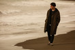 Leinwandbild Motiv 海岸を一人で歩く男性