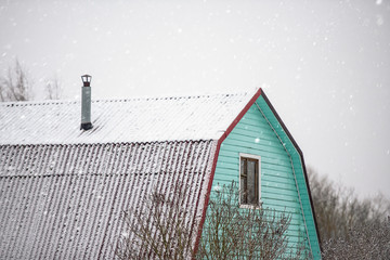  roof of the village house in winter and snowfall