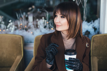 Wall Mural - Woman drinking coffee on Christmas city street.