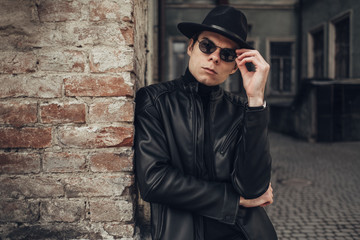 Portrait of Stylish Young Man in Black Leather Jacket and Hat