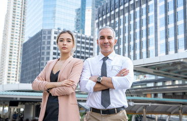 Concept of partnership in business. Young man and woman standing  at the office looking at the camera with confident smiles at the success of their partnership.