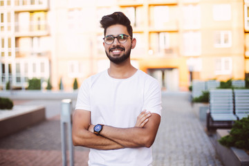 Young man indian smiling and looking at camera. Portrait of a happy handsome young man in a urban street.