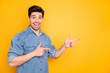 Photo of cheerful astonished man pointing into empty space with excitement on face isolated vivid color background