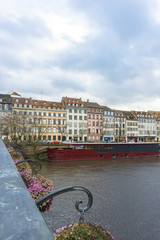 Poster - vertical Strasbourg city view with river barge and old houses lining the canals