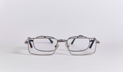 Two pairs of glasses are arranged one after another, like two people.  Glasses close-up isolated on a white background