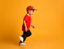 Smiling Little Boy Running Right Over Yellow Background