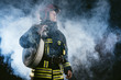 © alfa27 - young fire fighter holding rope in hands ready to save and protect from fire