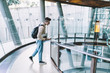 © GalakticDreamer - Young man looking down while standing on floor with glass fence