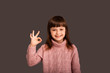 © Marharyta Hanhalo - I'm OK, I'm fine, the girl shows a gesture of approval with one hand. A happy and carefree childhood, a golden time for a child