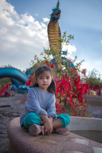 Young Girl Sit Thai Naga Statue In The Phu Manorom View