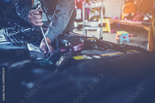 Fotografía technician working on checking and service car in workshop garage; technician r